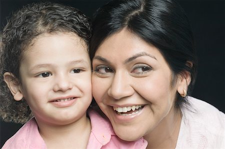 Close-up of a mid adult woman with her daughter smiling Foto de stock - Sin royalties Premium, Código: 630-01877538