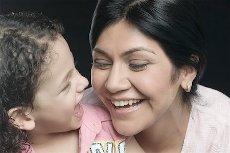 Close-up of a mid adult woman with her daughter smiling Stock Photo - Premium Royalty-Free, Code: 630-01877539