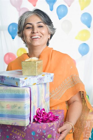 simsearch:630-01131008,k - Portrait of a mature woman holding a stack of gifts Foto de stock - Sin royalties Premium, Código: 630-01877557
