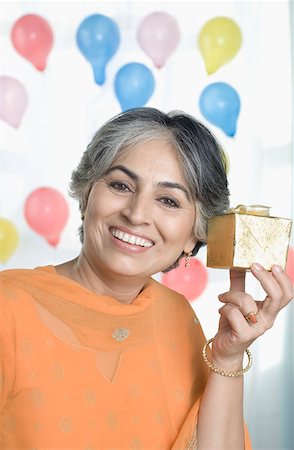 simsearch:630-01877587,k - Portrait of a mature woman holding a gift and smiling Stock Photo - Premium Royalty-Free, Code: 630-01877559