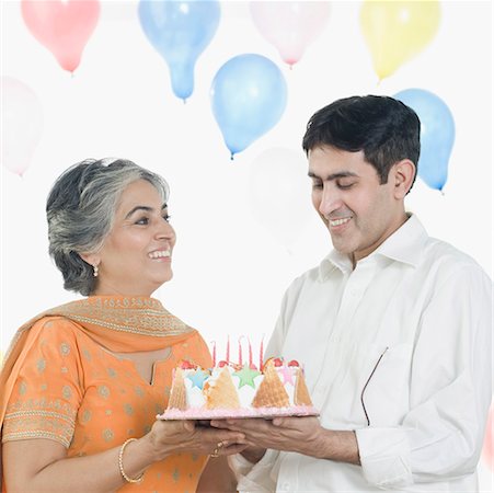 Femme mature avec son fils tenant un gâteau d'anniversaire Photographie de stock - Premium Libres de Droits, Code: 630-01877563