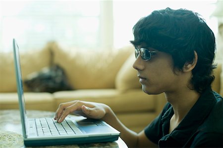 sunglasses on head - Close-up of a teenage boy using a laptop Stock Photo - Premium Royalty-Free, Code: 630-01877704