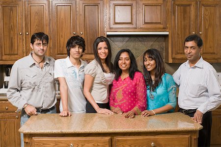 smile desi girl images - Portrait of a group of people smiling and standing in the kitchen Stock Photo - Premium Royalty-Free, Code: 630-01877721