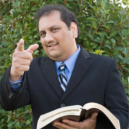 desi adults - Portrait of a mature man holding a book and pointing forward Stock Photo - Premium Royalty-Free, Code: 630-01877809