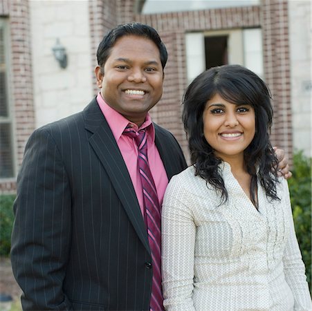 desi adults - Portrait of a mid adult man standing with his arm around a young woman and smiling Stock Photo - Premium Royalty-Free, Code: 630-01877814