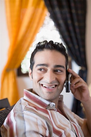 simsearch:630-01873329,k - Side profile of a young man talking on a mobile phone and smiling Foto de stock - Sin royalties Premium, Código: 630-01872200