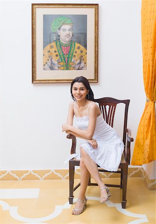 simsearch:630-01191733,k - Portrait d'une jeune femme assise avec les jambes croisées à genou et souriant Photographie de stock - Premium Libres de Droits, Code: 630-01872218