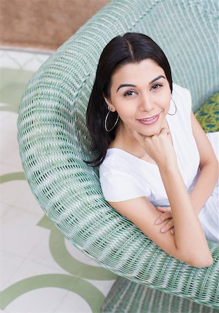 simsearch:630-01129601,k - Portrait of a young woman sitting on a couch with her hand on her chin Foto de stock - Royalty Free Premium, Número: 630-01872305