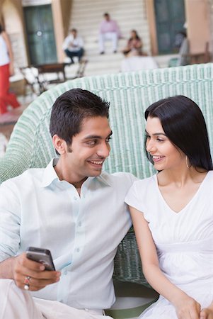simsearch:630-01874614,k - Young couple sitting on a couch and smiling Stock Photo - Premium Royalty-Free, Code: 630-01872312