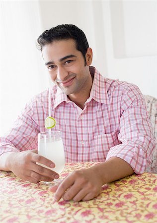 shirt rolled sleeves - Portrait d'un jeune homme tenant un verre de jus de citron et souriant Photographie de stock - Premium Libres de Droits, Code: 630-01872385