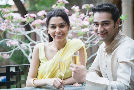 simsearch:630-01872567,k - Portrait of a young couple holding champagne flutes and smiling Foto de stock - Sin royalties Premium, Código: 630-01872527