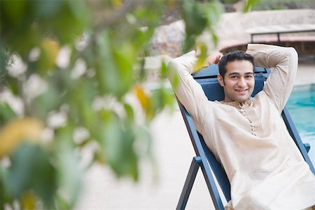 simsearch:630-01872996,k - Portrait of a young man sitting on a deck chair Foto de stock - Sin royalties Premium, Código: 630-01872521