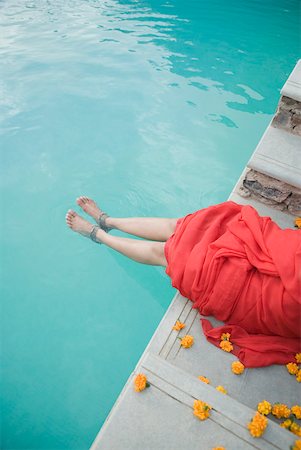 Vue en coupe basse d'une femme assise au bord de la piscine Photographie de stock - Premium Libres de Droits, Code: 630-01872547