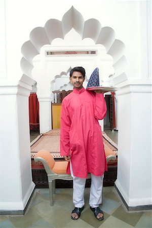 Portrait of a young man carrying a tea tray Stock Photo - Premium Royalty-Free, Code: 630-01872556