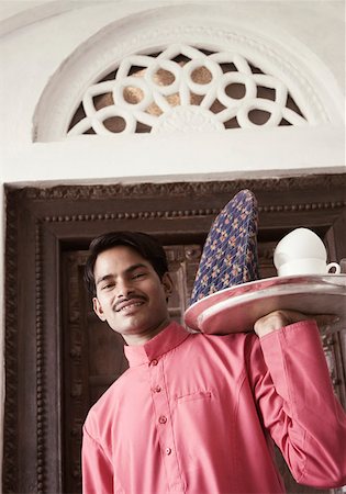 simsearch:630-01872567,k - Portrait of a young man carrying a tea tray and smiling Foto de stock - Sin royalties Premium, Código: 630-01872567