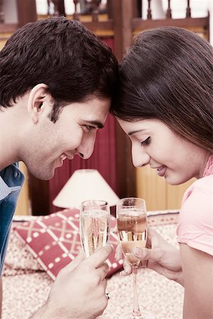 Young couple toasting with champagne flutes Stock Photo - Premium Royalty-Free, Code: 630-01872611