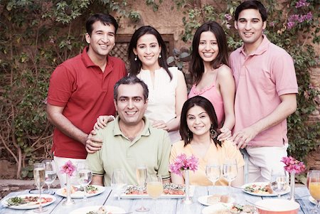 Portrait of a group of people at a dining table and smiling Stock Photo - Premium Royalty-Free, Code: 630-01872837