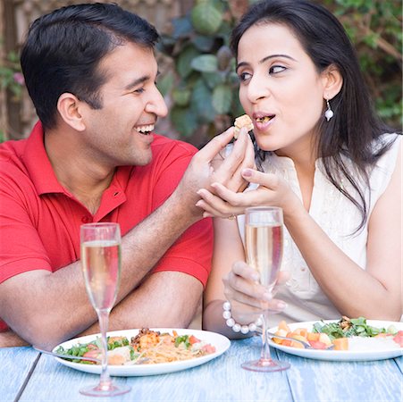 photo of a woman feeding her husband food - Close-up of a mid adult man feeding food to a mid adult woman Stock Photo - Premium Royalty-Free, Code: 630-01872841