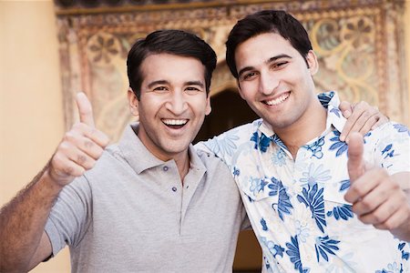 Portrait of a mid adult man and a young man showing a thumbs up sign Stock Photo - Premium Royalty-Free, Code: 630-01872877