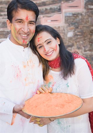 Portrait of a mid adult couple holding a plate of powder paint and smiling Stock Photo - Premium Royalty-Free, Code: 630-01873025