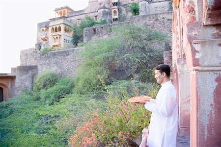 powder paint - Man holding plate of powder paint at balcony of fort, Neemrana Fort Palace, Neemrana, Alwar, Rajasthan, India Stock Photo - Premium Royalty-Free, Code: 630-01873020