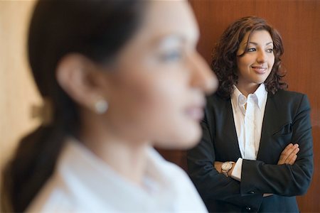 simsearch:630-01873210,k - Businesswoman standing with her arms crossed and smiling Fotografie stock - Premium Royalty-Free, Codice: 630-01873102