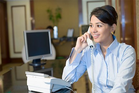 Close-up of a businesswoman talking on the telephone and smiling Stock Photo - Premium Royalty-Free, Code: 630-01873187