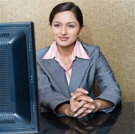 recepção - Female receptionist sitting at a hotel reception in front of a desktop PC Foto de stock - Royalty Free Premium, Número: 630-01873181