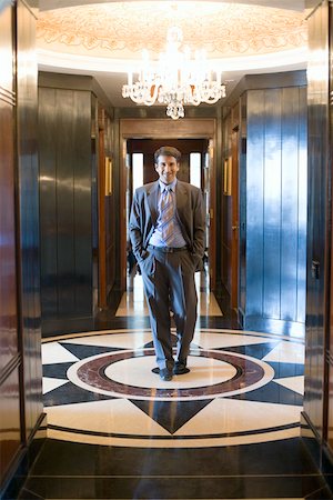 Portrait of a businessman walking with his hands in his pockets Stock Photo - Premium Royalty-Free, Code: 630-01873192