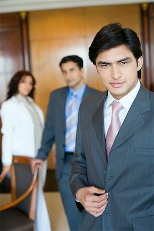 Portrait of a businessman with two business executives standing in the background Stock Photo - Premium Royalty-Free, Code: 630-01873209