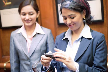 simsearch:630-01130741,k - Businesswoman looking at a digital camera with another businesswoman standing beside her Stock Photo - Premium Royalty-Free, Code: 630-01873230