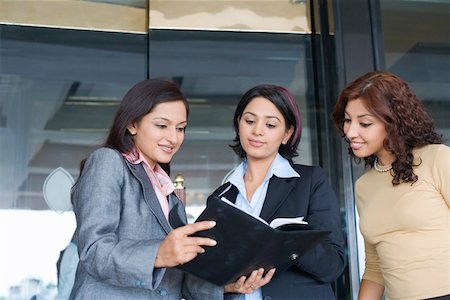 simsearch:630-01130741,k - Three businesswomen standing together and looking at a file Stock Photo - Premium Royalty-Free, Code: 630-01873267