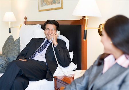 Businessman talking on the telephone with a businesswoman sitting in front of him Stock Photo - Premium Royalty-Free, Code: 630-01873289