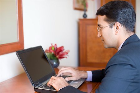 Side profile of a businessman working on a laptop Foto de stock - Sin royalties Premium, Código: 630-01873295