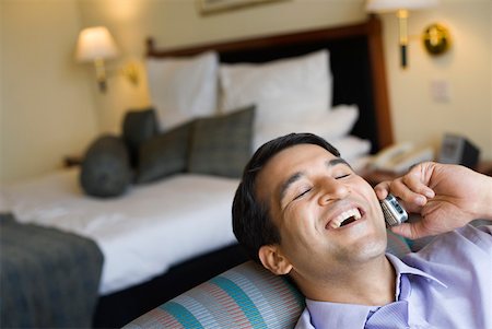 pillows in hotel room - Businessman talking on a mobile phone and smiling Stock Photo - Premium Royalty-Free, Code: 630-01873322