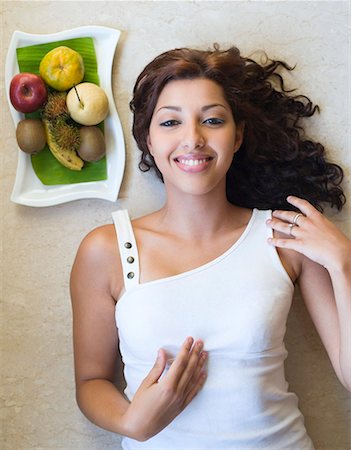 poison - Portrait d'une jeune femme se trouvant près d'un plateau de fruits et souriant Photographie de stock - Premium Libres de Droits, Code: 630-01873359