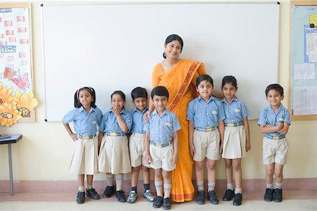 standing photos of girls in saree - Portrait d'un enseignant permanent avec des enfants d'âge scolaire et souriant Photographie de stock - Premium Libres de Droits, Code: 630-01873536