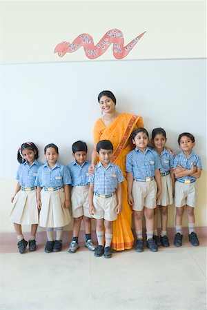 standing photos of girls in saree - Portrait of a teacher standing with schoolchildren and smiling Stock Photo - Premium Royalty-Free, Code: 630-01873537