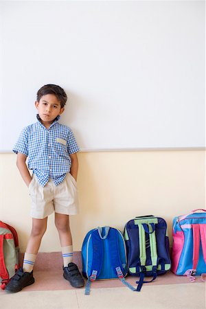 simsearch:630-01873782,k - Portrait of a schoolboy standing beside schoolbags in a classroom Foto de stock - Sin royalties Premium, Código: 630-01873549