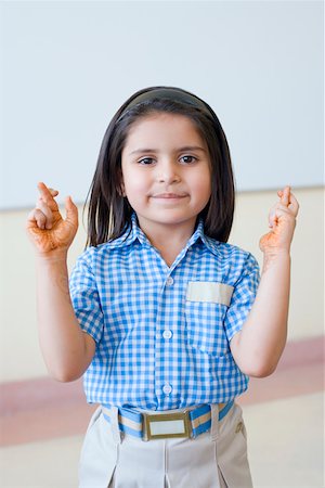 Portrait of a schoolgirl with her fingers crossed Foto de stock - Sin royalties Premium, Código: 630-01873559