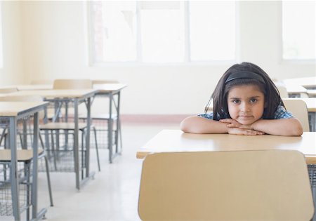 Portrait of a schoolgirl leaning on a desk in a classroom Foto de stock - Sin royalties Premium, Código: 630-01873589