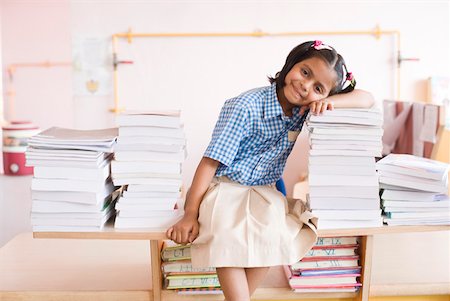simsearch:630-01873552,k - Porträt einer Schülerin über einen Stapel Bücher gestützt und lächelnd Stockbilder - Premium RF Lizenzfrei, Bildnummer: 630-01873615