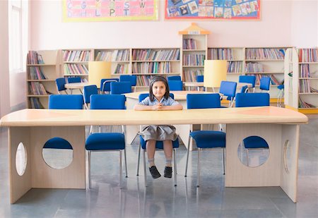 Portrait of a schoolgirl sitting at a desk in a library Stock Photo - Premium Royalty-Free, Code: 630-01873639
