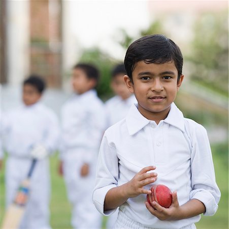 simsearch:630-01873684,k - Portrait of a boy holding a cricket ball and smiling Fotografie stock - Premium Royalty-Free, Codice: 630-01873667