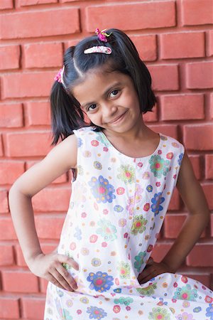 Portrait of a girl standing in front of a wall and smiling Foto de stock - Sin royalties Premium, Código: 630-01873660