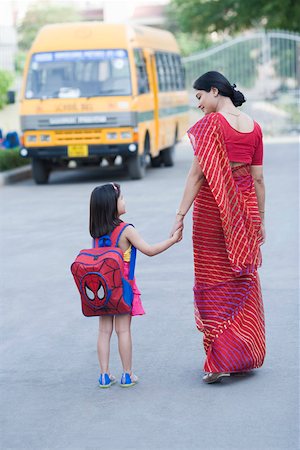 school kids mom - Rear view of a mid adult woman holding hand of her daughter and walking on the road Stock Photo - Premium Royalty-Free, Code: 630-01873703