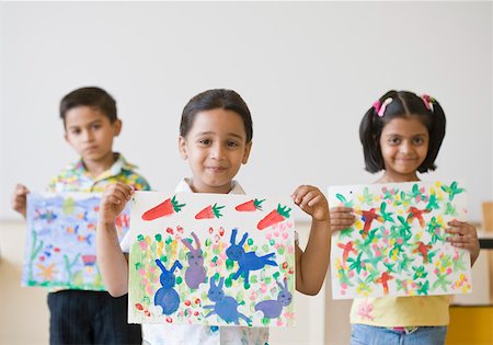 simsearch:630-01873486,k - Two schoolboys with a schoolgirl holding their paintings Foto de stock - Royalty Free Premium, Número: 630-01873736
