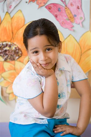 smirk girl - Portrait of a girl sitting with her hand on her chin Stock Photo - Premium Royalty-Free, Code: 630-01873732