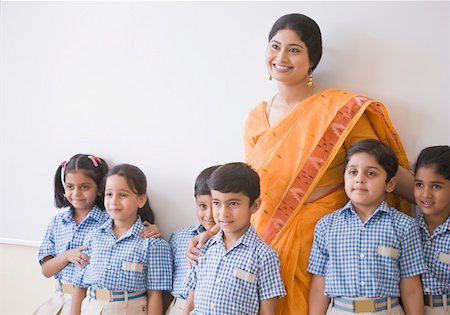 Female teacher and students standing by a whiteboard and smiling Foto de stock - Sin royalties Premium, Código: 630-01873767