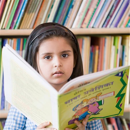 Portrait of a schoolgirl holding a book in a library Stock Photo - Premium Royalty-Free, Code: 630-01873795